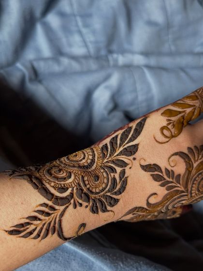 A stylish Arabic vine design that trails diagonally across the back of the hand.