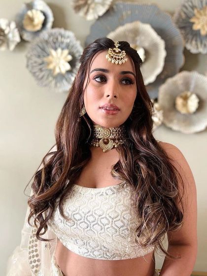 A confident pose showing off this subtle yet stunning makeup. The focus is on creating a flawless base and adding a touch of shimmer to the eyes for a bright, awake look.