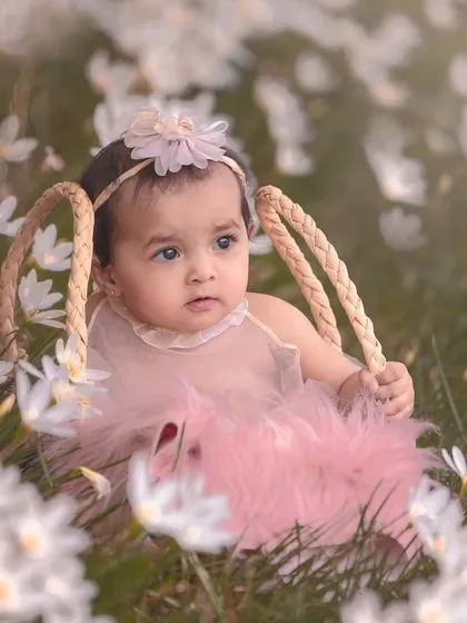 A touch of magic for this outdoor session. This baby girl sits in a basket amidst a field of spring flowers, looking like a little fairy.