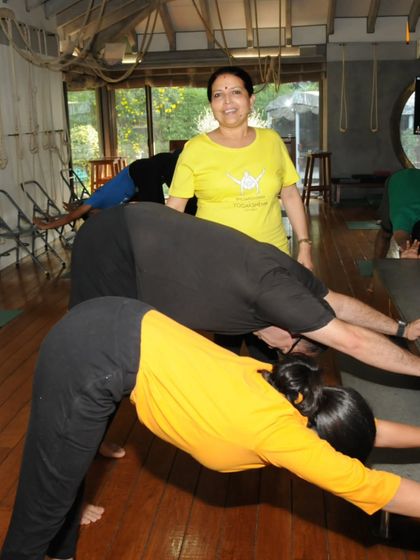 I am guiding students in a supported forward bend. The use of the stage as a prop allows for a deep and safe extension of the spine.