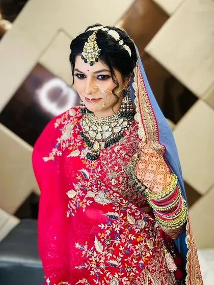 A side-profile of the bride, highlighting the beautiful embroidery on her dupatta and the intricate details of her makeup and jewelry.