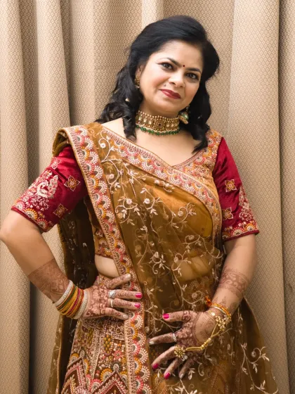 A posed bridal portrait showing off the beautiful mehendi on her hands and the details of her wedding lehenga.