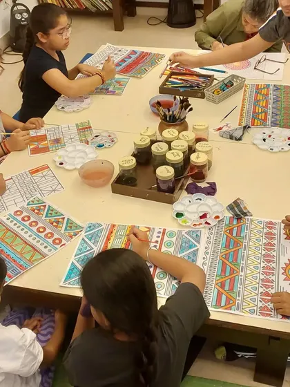 Students working on their African Kente cloth patterns. The tables are always full of color, supplies, and the focused energy of artists at work.