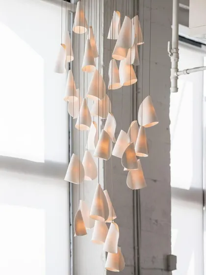 A beautiful spiral chandelier created with dozens of Bocci 21 pendants. This type of large-scale installation is ideal for double-height entryways or commercial lobbies.