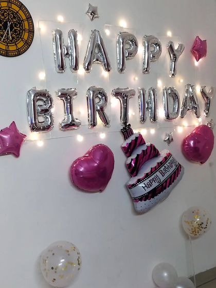 A simple wall decoration that still feels special. I used silver foil "Happy Birthday" letters, heart and cake-shaped foil balloons, and fairy lights to add a warm glow to the setup.