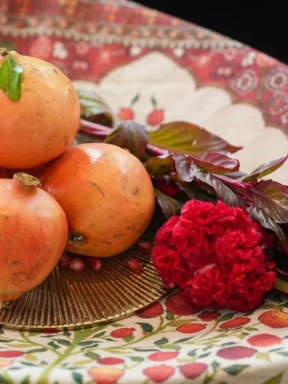 Another beautiful composition of fresh pomegranates and flowers, showcasing the core elements of the event's theme.