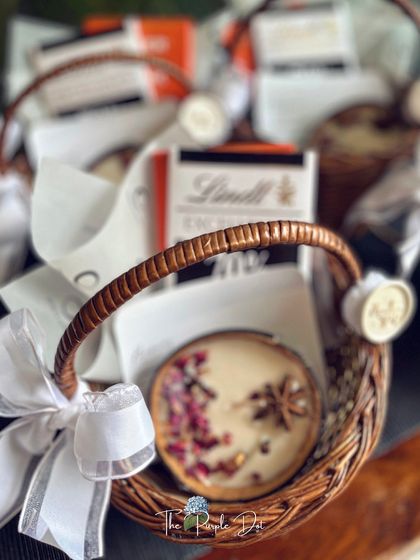 Not just gifts, but curated moments. These small wicker baskets hold a beautiful artisanal candle and gourmet chocolate, perfect as a thank you gift or party favor.