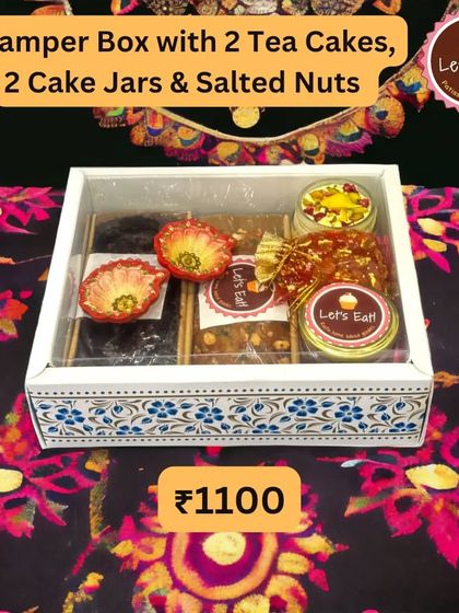 A beautifully arranged hamper box with two tea cakes, two cake jars, and salted nuts, presented in a decorative box with a clear lid. This is a great option for corporate Diwali gifts.