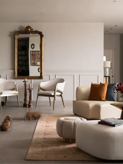 A comfortable seating arrangement in our experience center, where classic elements meet contemporary design. A vintage-style gilt mirror is paired with modern curved sofas and armchairs, demonstrating how I mix styles to create timeless and welcoming spaces.