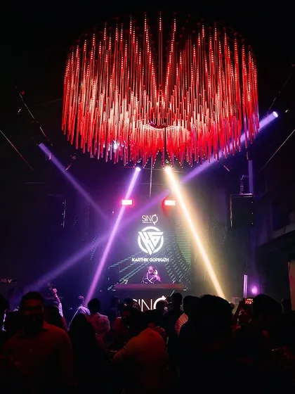 An epic wide shot of the main room at Sinq, Goa, with me on the stage under a massive chandelier.