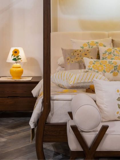 A detail of our four-poster bed, showing the custom side table and the artfully arranged, hand-embroidered linens by Gaurang Home. Every element is chosen to contribute to a feeling of calm, striking beauty.