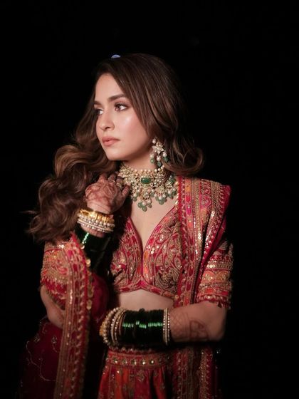 A stunning portrait against a dark background. This really makes the bridal makeup pop, showcasing the expertly blended eyeshadow, the subtle contour, and the overall radiance of the skin.