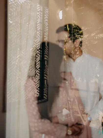 An artistic shot taken through a reflection, creating a dreamy and layered effect. This creative technique adds a touch of mystery and romance to the couple's portrait.