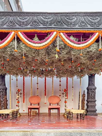 A close-up of a temple-style mandap with a stunning ceiling of dried foliage and hanging flowers. The intricate details and traditional elements create a truly sacred space.