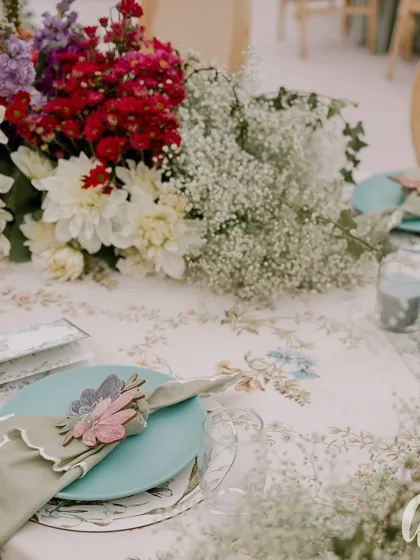 We believe luxury is in the details. This tablescape from a spring luncheon features custom floral-print linens, delicate floral napkin rings, and a centerpiece of fresh baby's breath, showing how thoughtful details create a cohesive and beautiful guest experience.