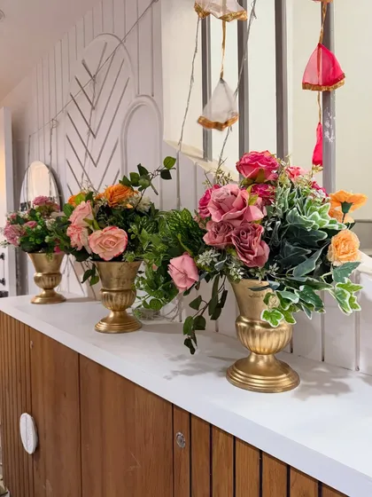 Elegant details for a Mehendi event. We arranged beautiful bouquets of pink and peach roses in golden vases to add a touch of sophistication to the decor.