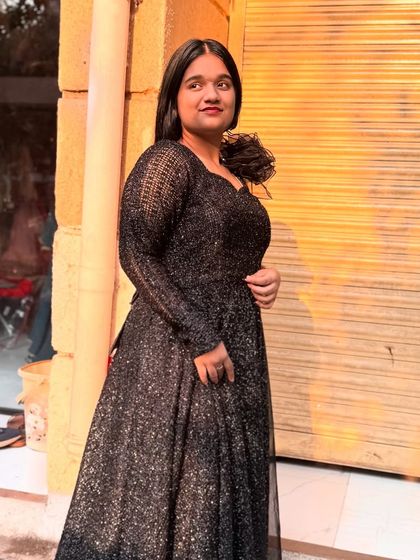 This long-sleeved black shimmer gown is an elegant and sophisticated option for any formal event.