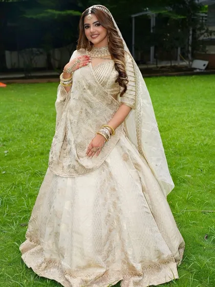 For the bride who loves understated elegance, I offer modern ivory and white lehengas. This rental outfit features delicate gold embroidery, offering a sophisticated and regal look for a wedding ceremony or reception.