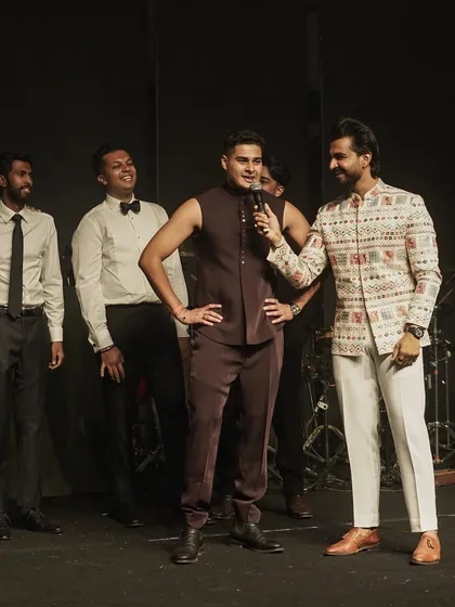 Engaging with the groomsmen during a Sangeet performance. My interactive style ensures that even the guests on stage are having a great time.