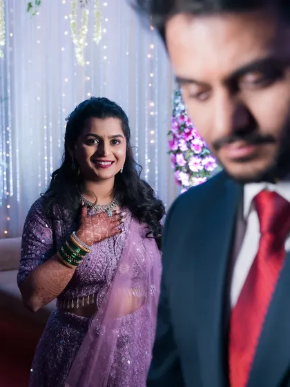 A bride looks lovingly at her groom, who is in the foreground.