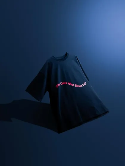 A minimalist shot of a t-shirt against a deep blue background. The simple, clean lighting and composition make the red text pop, creating a bold and graphic image.
