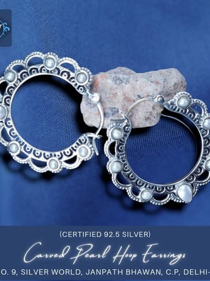 These carved pearl hoop earrings offer a unique twist on the classic hoop. The outer edge is scalloped and studded with small pearls, adding a touch of ethnic grace.