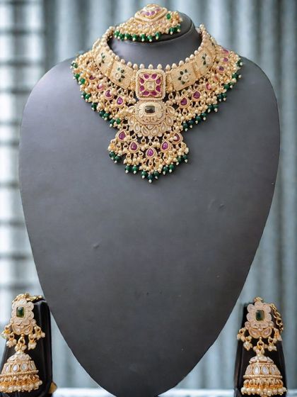The full view of this elegant kundan set against a dark background, highlighting its rich colors.