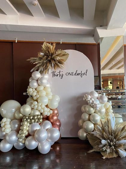A full view of the "Thirty Onederful" birthday backdrop. The elegant arch, sophisticated balloon colors, and dried pampas grass accents come together to create a beautiful and trendy setting for a 31st birthday.