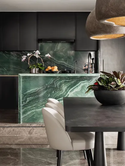 The kitchen is the heart of the home, and this one makes a bold statement with its stunning green marble island. Paired with sleek, dark cabinetry, the vibrant stone becomes the centerpiece of the open-plan dining area. It’s a perfect blend of functional design and high-impact luxury.