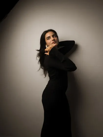 A studio session with a model in a black dress, showcasing a range of poses from pensive to powerful. The lighting is controlled to sculpt the subject and create a sophisticated mood.