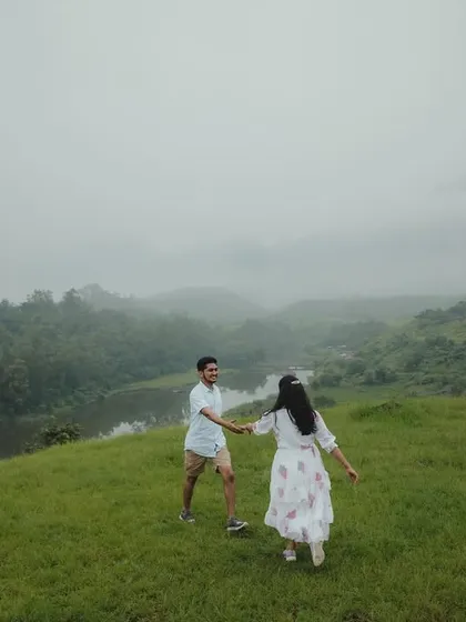 A candid moment of the couple walking hand-in-hand through the misty, rolling hills, creating a sense of journey and togetherness.