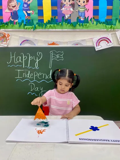 A young artist carefully dabs paint to create her version of the Indian flag. Our craft activities are designed to be accessible and engaging for every child.