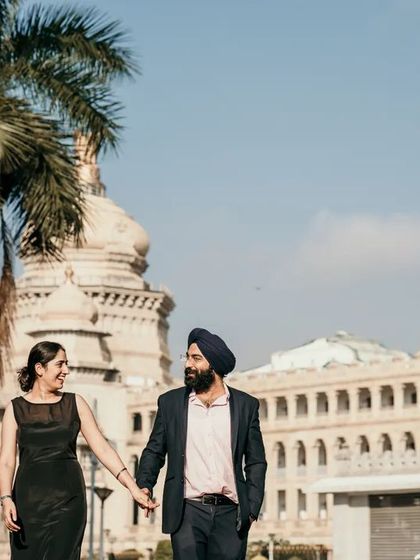 A couple walks hand-in-hand with an iconic Bangalore building behind them. This shot combines romance with a sense of place, creating a story rooted in the city.
