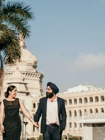 A couple walks hand-in-hand with an iconic Bangalore building behind them. This shot combines romance with a sense of place, creating a story rooted in the city.