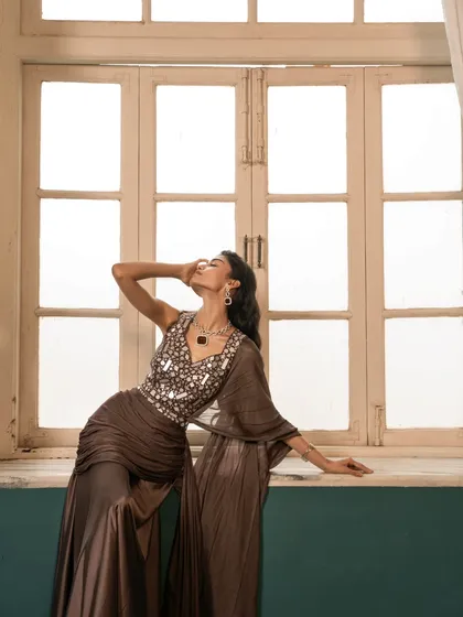 A dynamic pose against a backlit window, creating a silhouette that emphasizes the fluid movement of the draped garment. This shot is about capturing emotion and form.