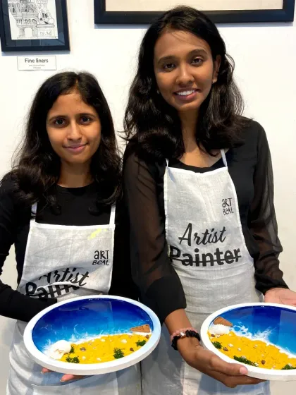 Two friends with their finished resin beach art. The joy of creating together is a key part of the Art Beat experience.