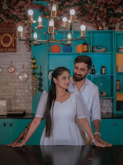 A stylish indoor night shoot in a colorful kitchen set. The warm lighting and modern decor create a chic and intimate setting for this couple's portrait.