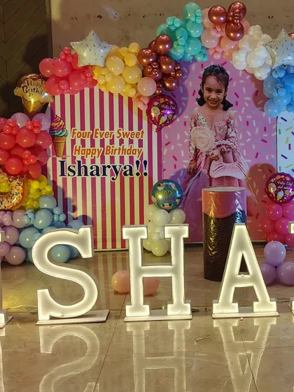 A close-up of the Candyland birthday setup, highlighting the details of the balloon arch and custom props.