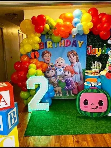 A fun and colorful Cocomelon theme for a second birthday. This setup includes a character backdrop, marquee number '2', and themed props like Cocomelon blocks, creating an immersive play area for the kids.