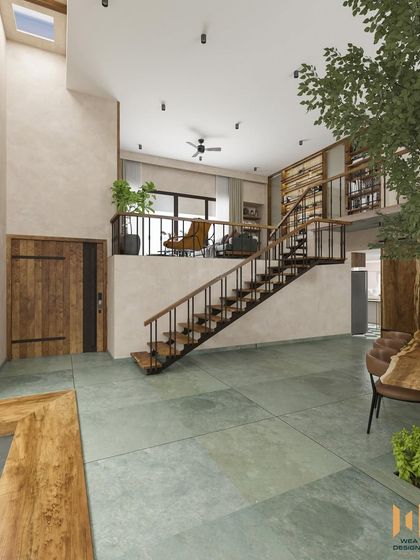A view from the ground floor looking up at the mezzanine and staircase, showcasing the home's vertical space and natural materials.