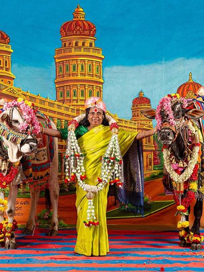 A vibrant archival print from the 'No Longer A Memory' series. Here, Gowramma stands proudly with decorated bulls against a theatrical studio backdrop, embodying the blend of rural life and imagined grandeur that defines Cop Shiva's work.