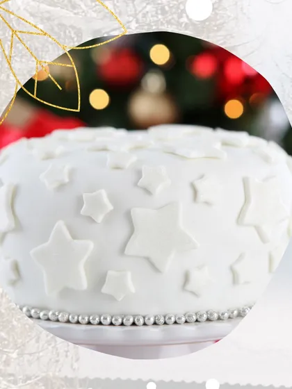 A pristine white Christmas cake decorated with delicate star shapes. This minimalist design is perfect for a sophisticated holiday party, offering a clean aesthetic without any fondant.