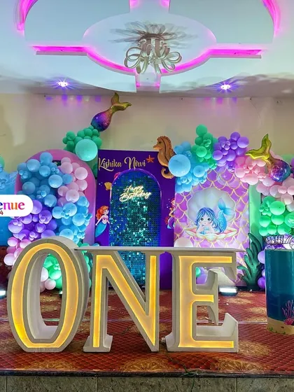 A magical mermaid theme for a first birthday celebration. I used a vibrant color palette and included details like a large mermaid tail, an under-the-sea backdrop, and illuminated letters.