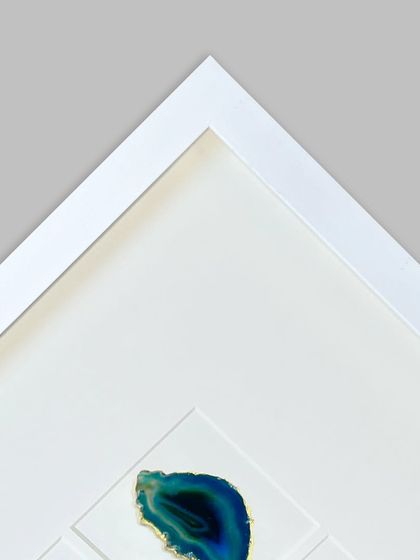 A corner detail of the agate stone frame, showing the sapphire blue stone. The deep polystyrene frame creates the shadow box effect, giving the piece significant visual depth.