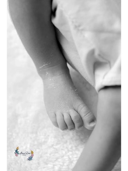 This black and white detail shot of a baby's foot showcases its perfect form and tiny toes, creating a beautiful and artistic memory.