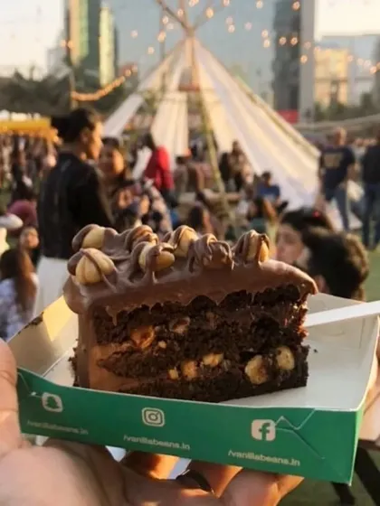 A slice of our cake held up against the backdrop of The Lil Flea. There's nothing like enjoying a fresh dessert in such a vibrant atmosphere.