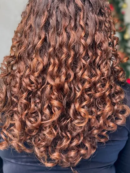 Getting clients ready for the holidays with a festive hair color. This warm-toned balayage was done without bleach, making it the perfect gift for healthy curls.