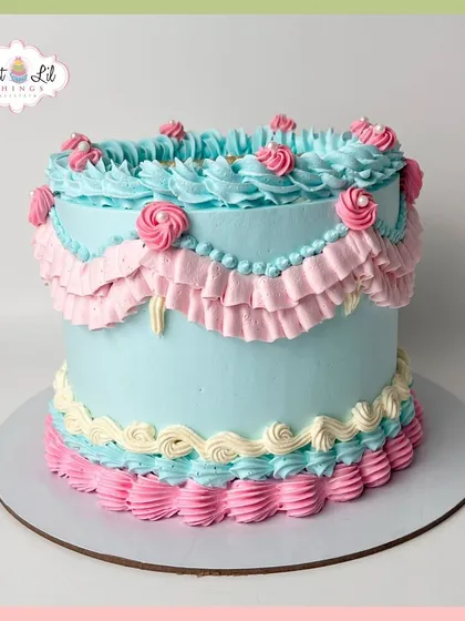 A charming vintage-style cake with delicate ruffled piping in pastel pink and blue.