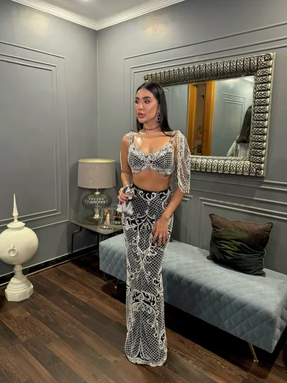 A client radiates sheer elegance in my signature charcoal black pearl-embellished skirt and intricately designed bralet with a flowing cape.