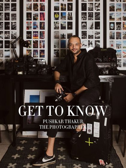 The cover image for a "Get to Know" series on photographer Pushkar Thakur. This portrait invites the viewer into his world, surrounded by the tools and results of his craft.